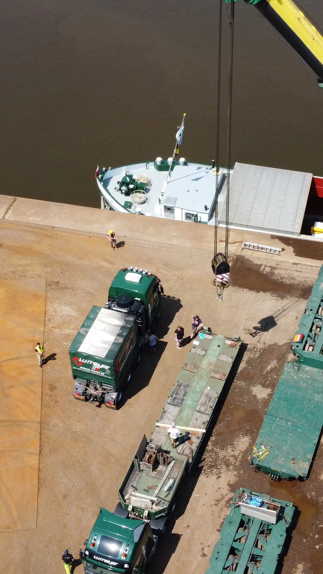 Eigener Lkw von W. Mayer beim Verladen einer Fracht auf ein Binnenschiff im Hafen