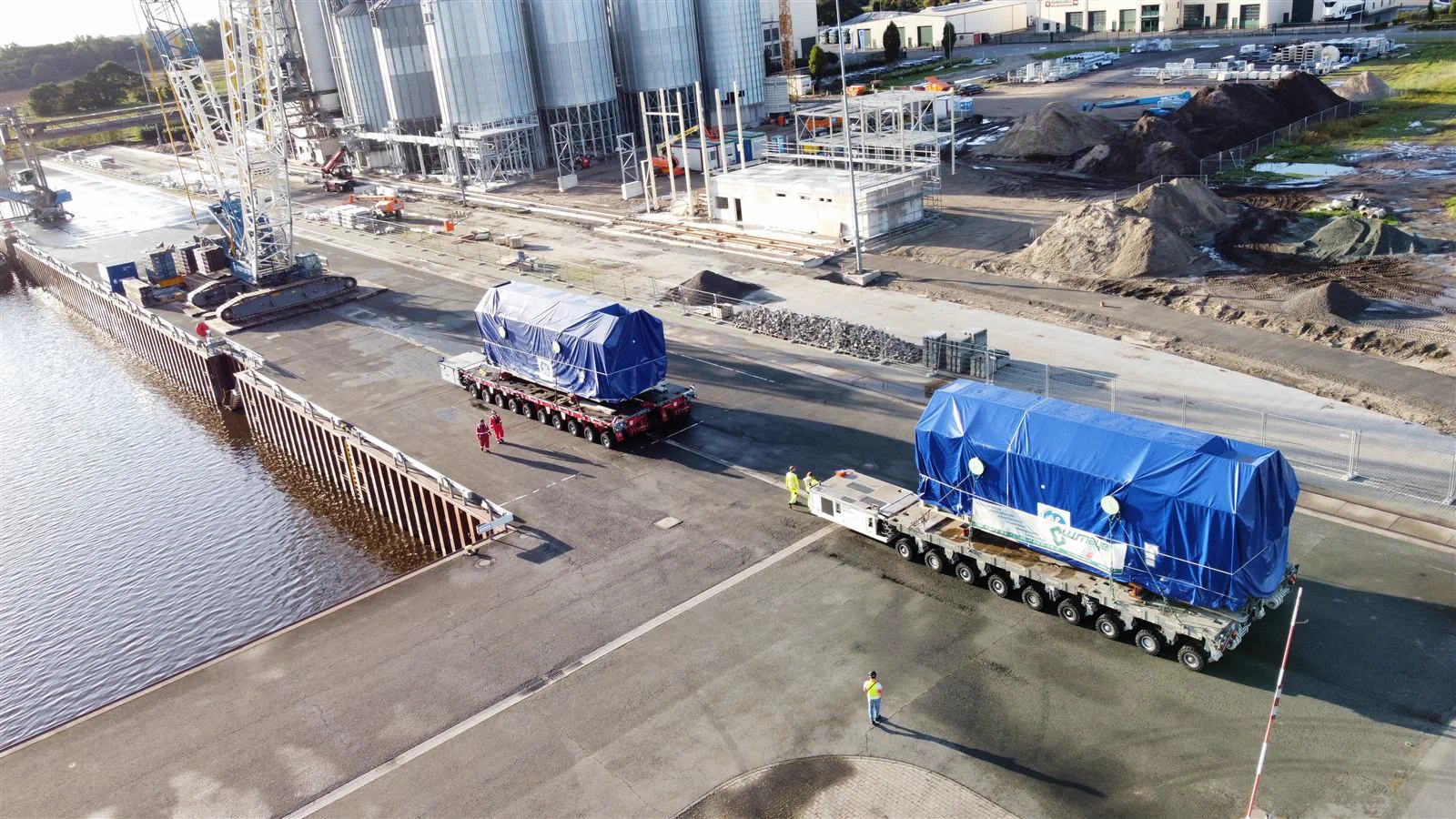 Schwerlasttransport von W. Mayer an einem Kai mit Silos im Hintergrund