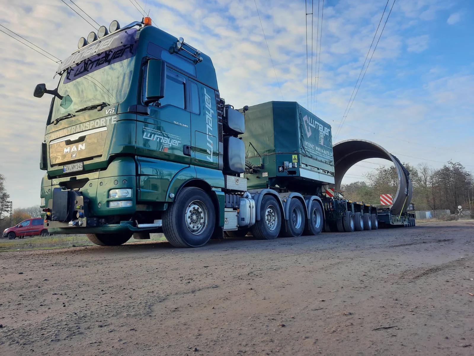 W. Mayer Schwerlastzug transportiert ein großes rundes Rohrsegment